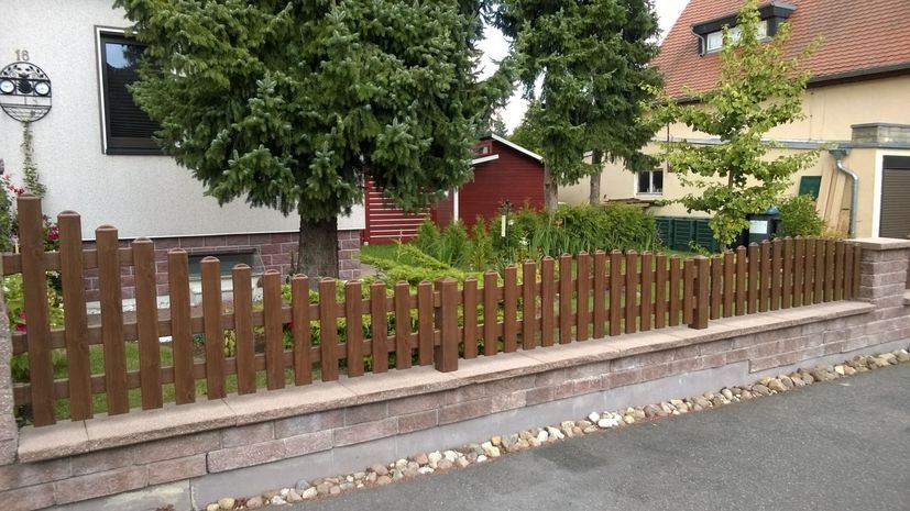 Gartenzaun aus PVC-Kunststoff in dunkelbraun auf Sockel montiert