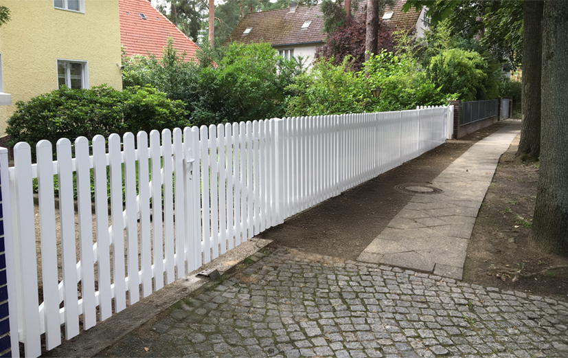 Weißer Lattenzaun streckt die Linie